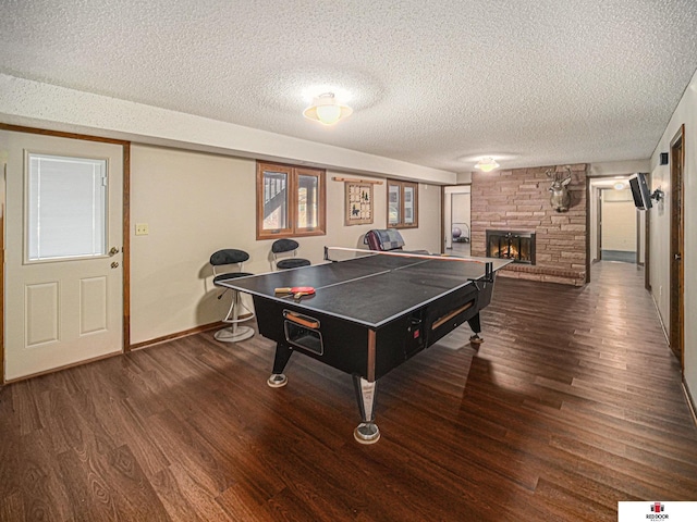 1521 Kingston Rd, Lincoln, NE 68506 - playroom with baseboards, a textured ceiling, wood finished floors, and a fireplace