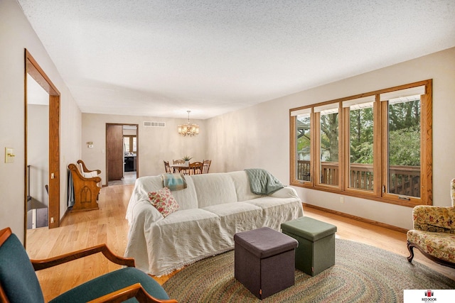 1521 Kingston Rd, Lincoln, NE 68506 - living room with light wood-style floors, a chandelier, and visible vents