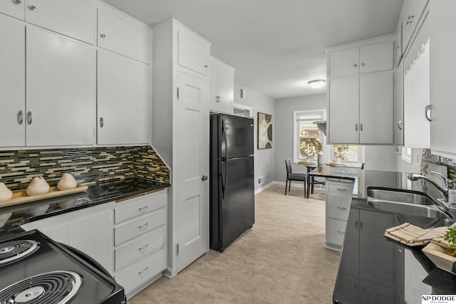 kitchen with decorative backsplash, dark countertops, a sink, black appliances, and white cabinetry