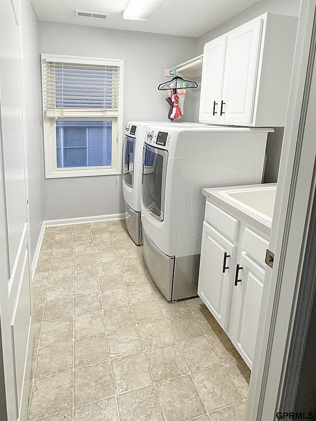 18063 Jones St, Elkhorn, NE 68022 - laundry room featuring baseboards, visible vents, cabinet space, and washing machine and clothes dryer