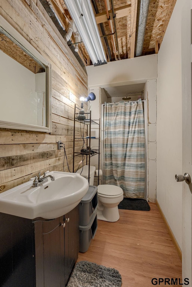 18063 Jones St, Elkhorn, NE 68022 - bathroom featuring wood finished floors, curtained shower, toilet, wooden walls, and a sink
