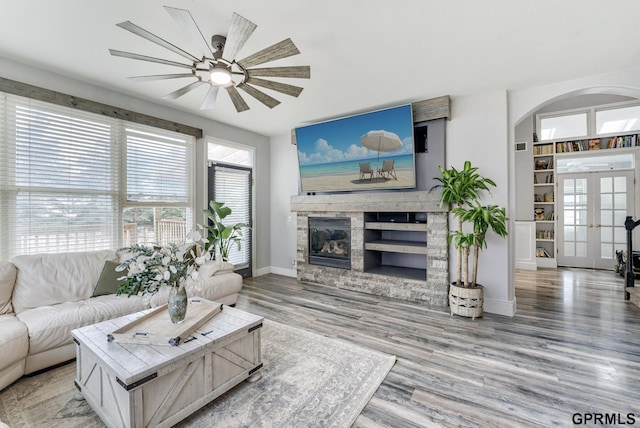 18063 Jones St, Elkhorn, NE 68022 - living area with a ceiling fan, french doors, arched walkways, a fireplace, and wood finished floors