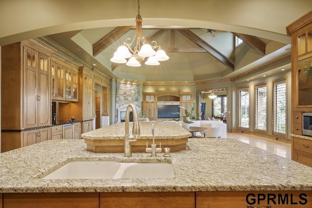 kitchen featuring brown cabinets, open floor plan, and a sink