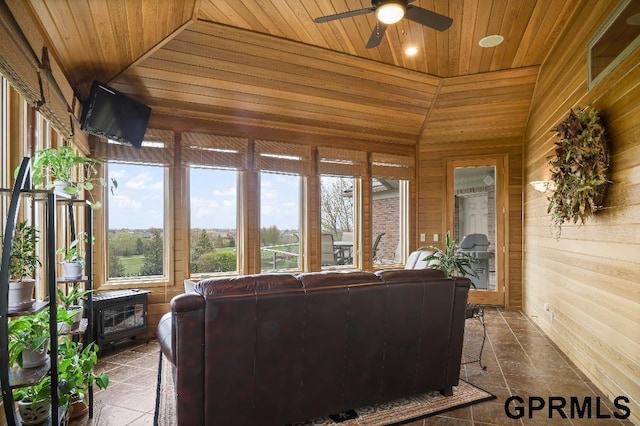 sunroom / solarium with wood walls, stone tile floors, vaulted ceiling, and wooden ceiling
