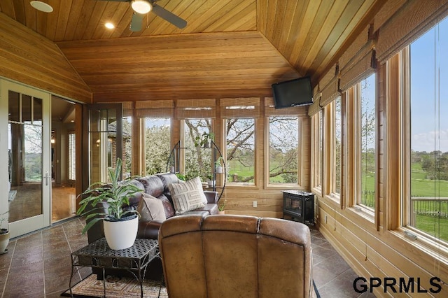 sunroom featuring vaulted ceiling, wooden ceiling, french doors, and a wood stove