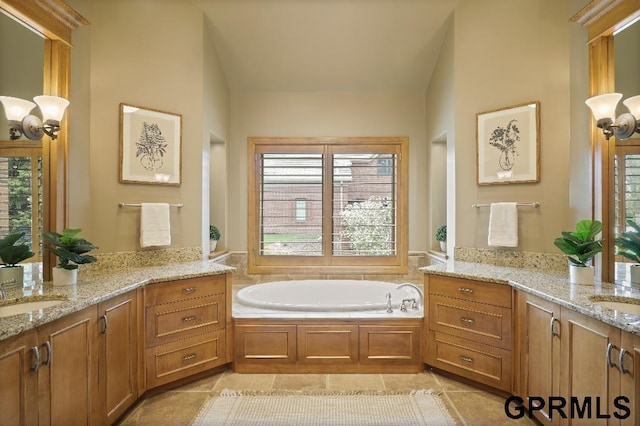bathroom with a garden tub, a sink, two vanities, and tile patterned flooring