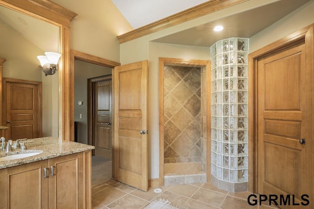 full bath with vaulted ceiling, a walk in shower, tile patterned flooring, and vanity