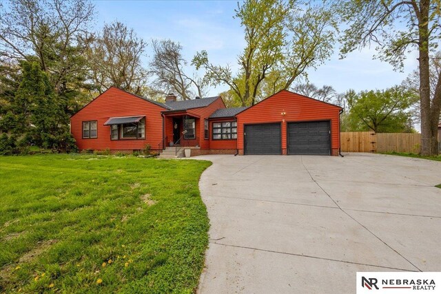 ranch-style home with fence, a front yard, a chimney, concrete driveway, and an attached garage