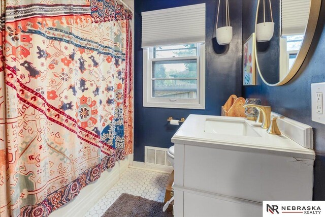 full bathroom with visible vents, vanity, shower / bath combination with curtain, toilet, and baseboards