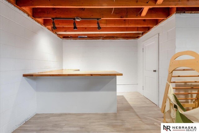 interior space with light wood-type flooring and concrete block wall