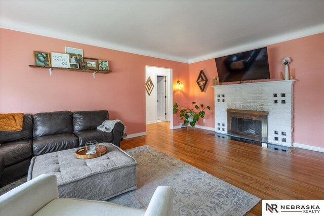 living room featuring baseboards, wood finished floors, and a fireplace