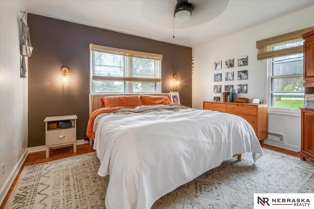 bedroom featuring light wood-style floors, a ceiling fan, and baseboards