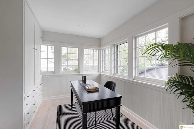 office area featuring light wood-type flooring, wainscoting, and baseboards