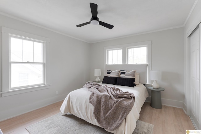 bedroom featuring a ceiling fan, baseboards, ornamental molding, and light wood-style flooring