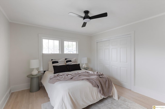 bedroom featuring light wood-style floors, baseboards, crown molding, and a closet
