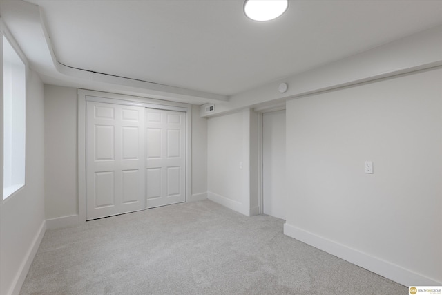 unfurnished bedroom featuring baseboards, carpet flooring, and a closet