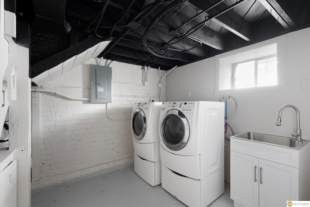 laundry room with a sink, electric panel, and washing machine and clothes dryer