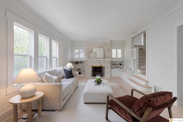 living room featuring a stone fireplace, light wood-style flooring, baseboards, visible vents, and ornamental molding