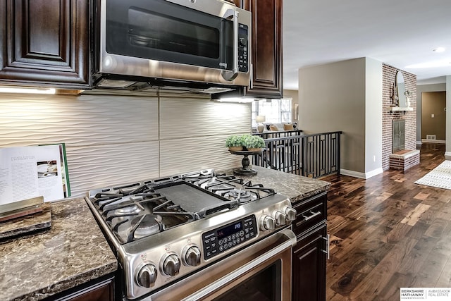 kitchen with appliances with stainless steel finishes, dark brown cabinets, baseboards, and dark wood-style floors