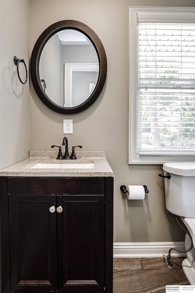 bathroom featuring plenty of natural light, baseboards, and vanity