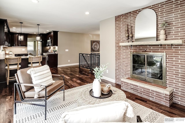 living area with dark wood-type flooring, baseboards, recessed lighting, and a fireplace