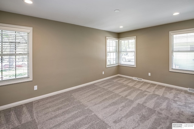 empty room with baseboards, a wealth of natural light, light carpet, and recessed lighting