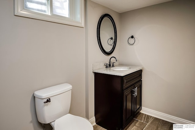 bathroom featuring vanity, toilet, baseboards, and visible vents