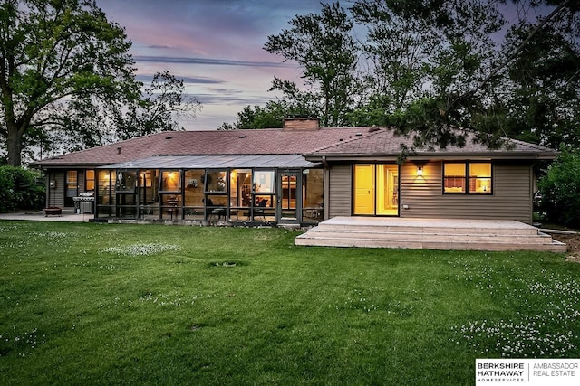 rear view of house with a lawn, a chimney, and a patio area