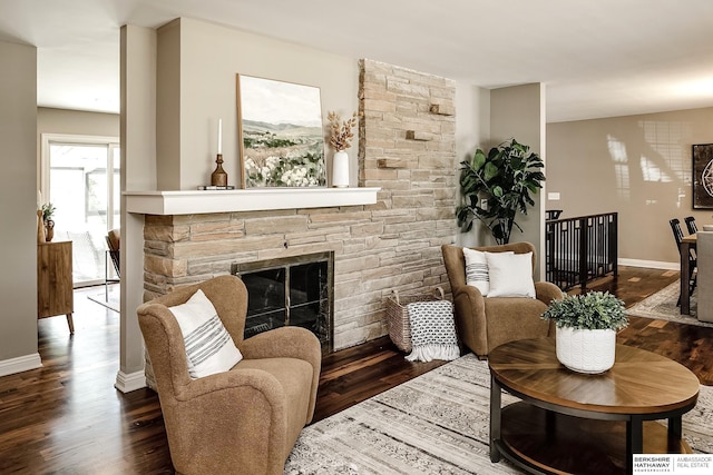 living room with wood finished floors, a fireplace, and baseboards