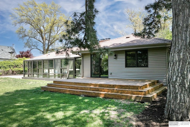 back of house featuring a sunroom, a wooden deck, a yard, and a shingled roof