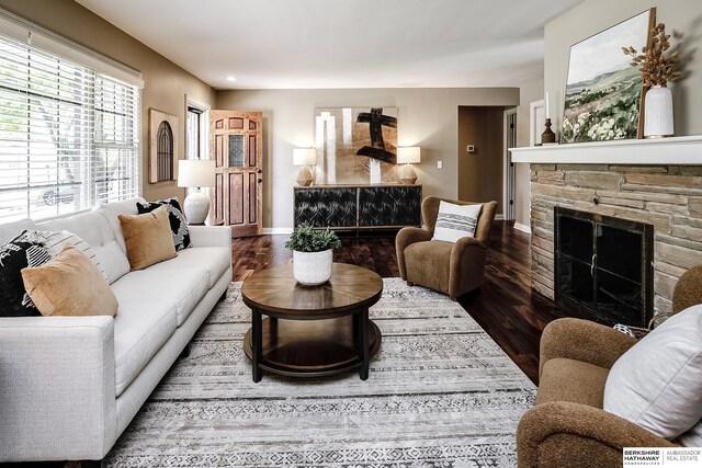 living room with baseboards, wood finished floors, a fireplace, and recessed lighting