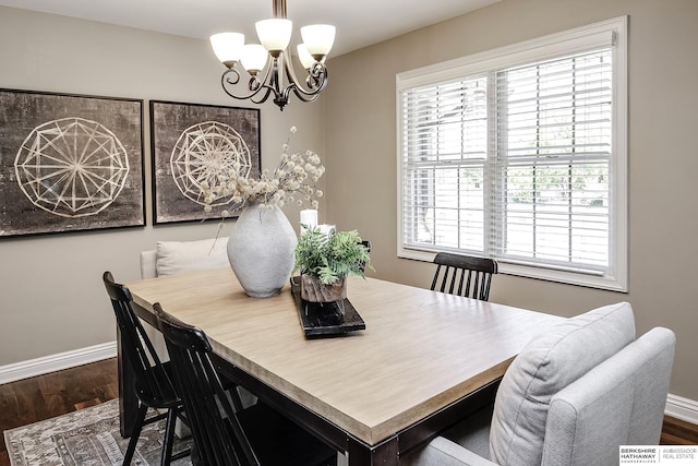 dining room with a chandelier, dark wood-style flooring, and baseboards