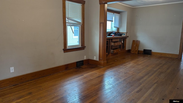 unfurnished living room featuring crown molding, plenty of natural light, hardwood / wood-style flooring, and visible vents