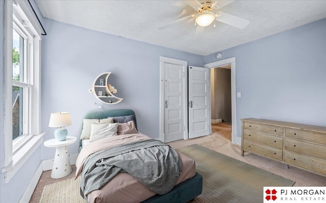 bedroom featuring carpet floors, baseboards, a ceiling fan, and a textured ceiling
