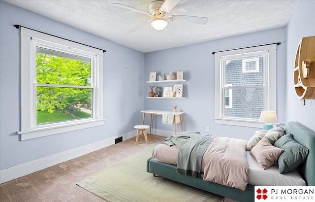 bedroom with carpet floors, a textured ceiling, a ceiling fan, and baseboards