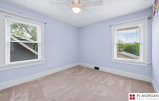 spare room featuring carpet, baseboards, and a ceiling fan