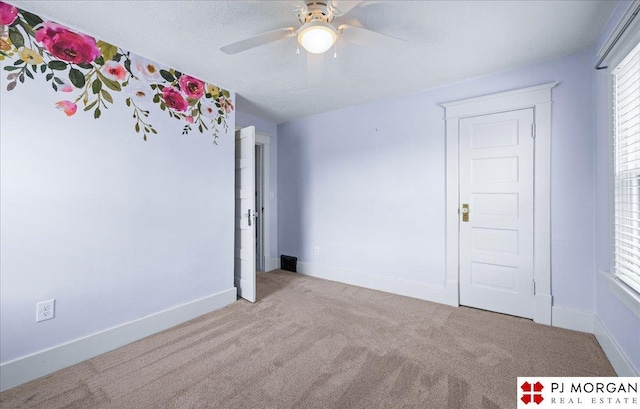 unfurnished room featuring carpet floors, ceiling fan, and baseboards
