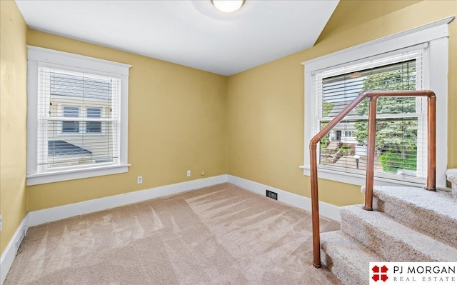 spare room featuring carpet and baseboards