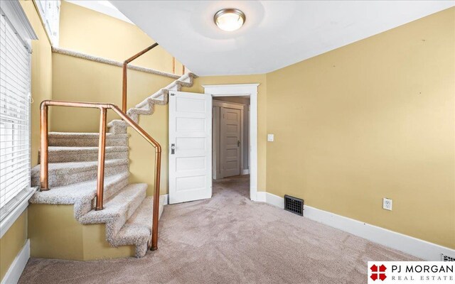 stairway featuring carpet flooring and baseboards