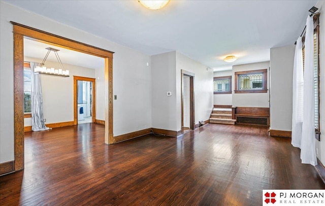 empty room with plenty of natural light, wood finished floors, and baseboards