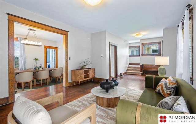 living area with wood finished floors, stairs, and baseboards