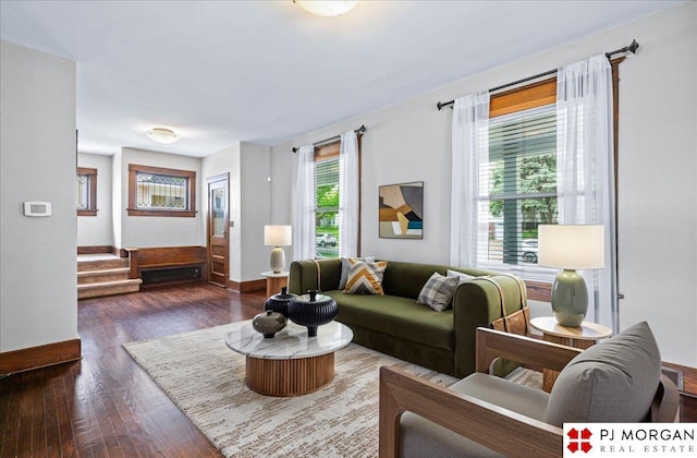 living room featuring dark wood finished floors, baseboards, and stairway