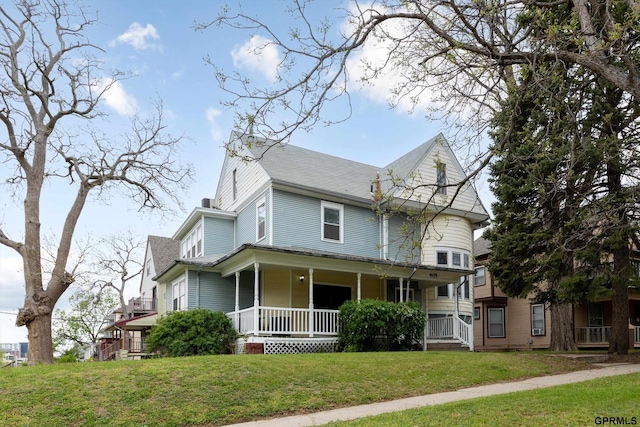 405 N 25th St, Lincoln, NE 68503 - victorian-style house with covered porch, roof with shingles, and a front yard