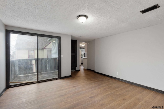 405 N 25th St, Lincoln, NE 68503 - empty room with baseboards, a textured ceiling, visible vents, and wood finished floors