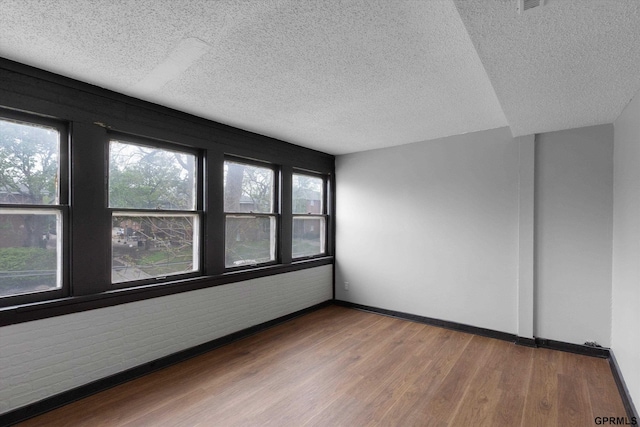 405 N 25th St, Lincoln, NE 68503 - spare room with baseboards, a textured ceiling, and wood finished floors