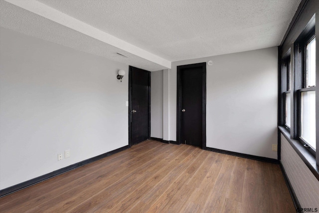 405 N 25th St, Lincoln, NE 68503 - unfurnished room with baseboards, a textured ceiling, and wood finished floors