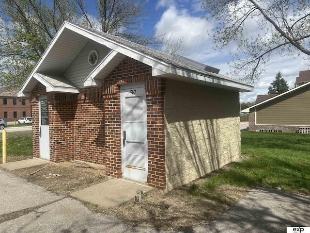 view of side of home with a yard and brick siding