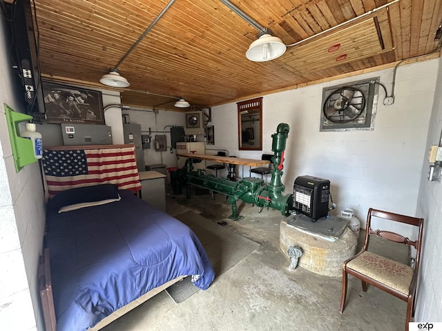 bedroom featuring concrete flooring, concrete block wall, wooden ceiling, and a wood stove