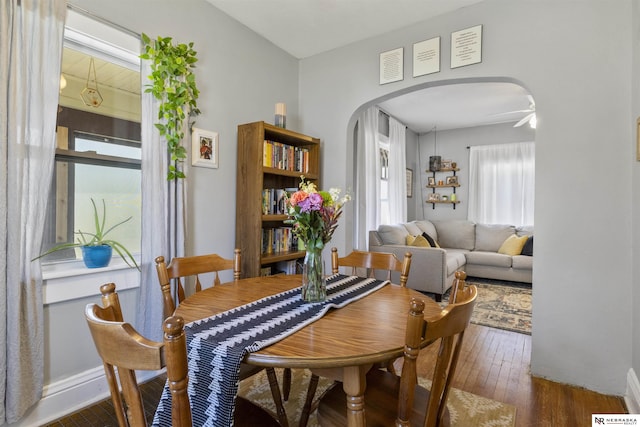 4504 Mayberry St, Omaha, NE 68106 - dining room with arched walkways, baseboards, and wood finished floors