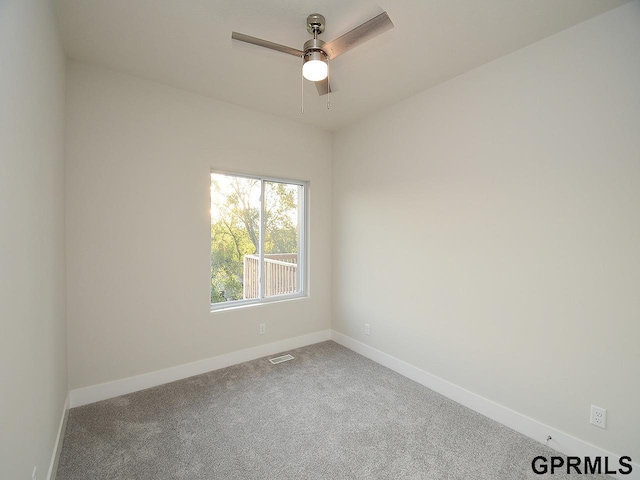 carpeted empty room featuring baseboards, ceiling fan, and visible vents